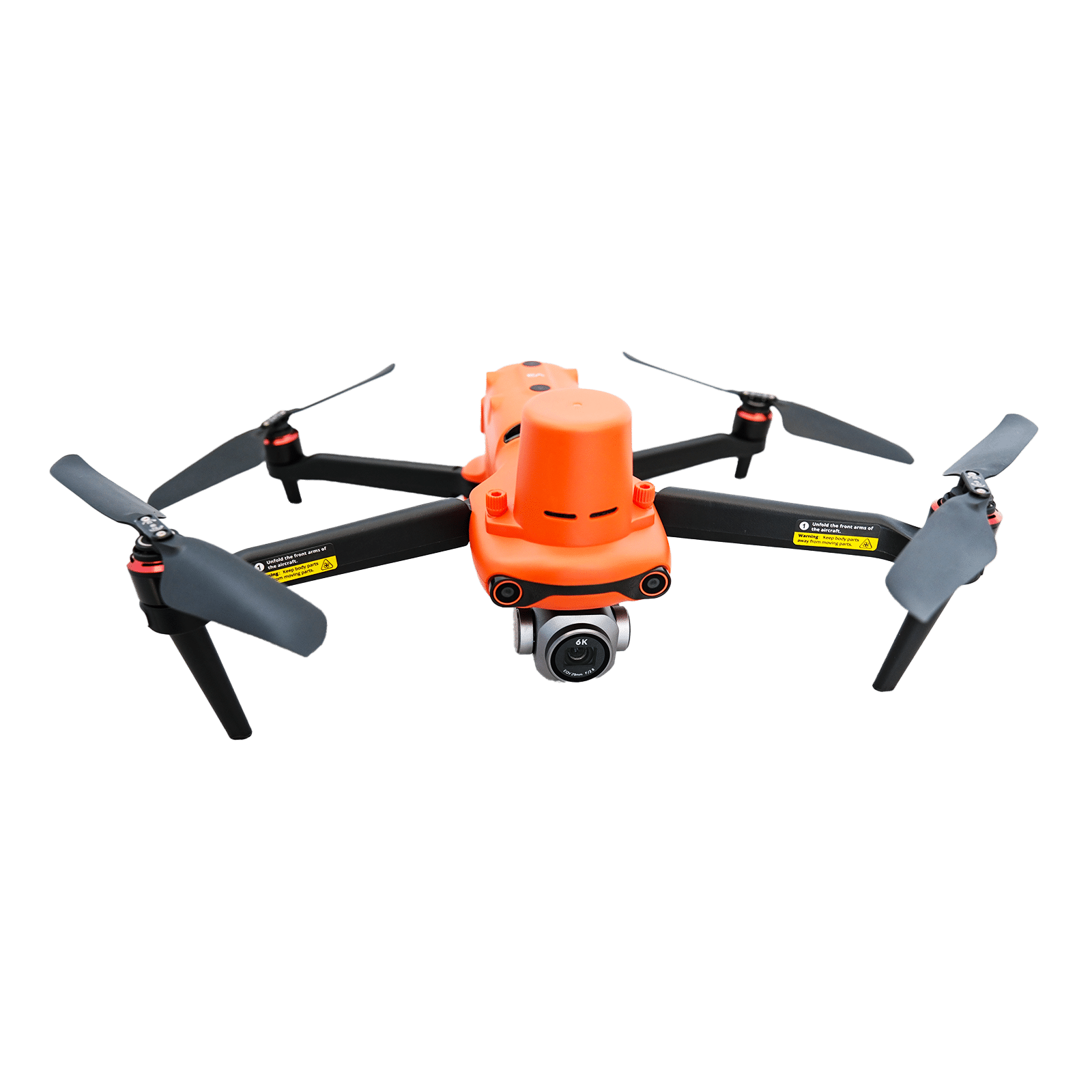 Orange quadcopter drone with four black propellers on a light speckled surface.